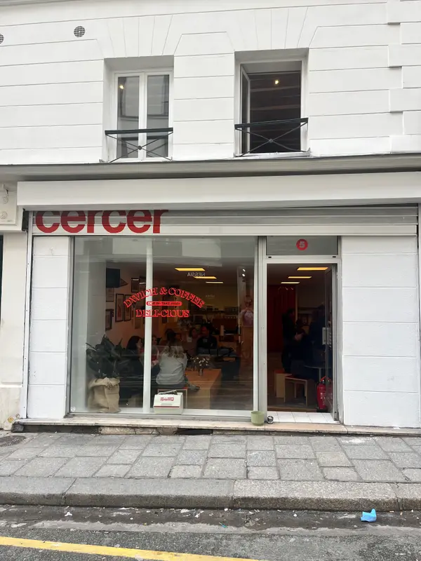 Cercer sandwich and coffee shop storefront in Paris with red signage, dine-in seating visible through large windows.
